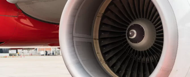 Close-up of an airplane engine turbine on a runway.