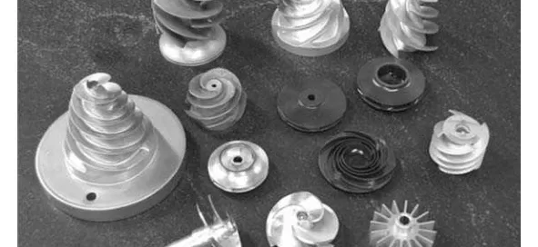 Various spiral-shaped metal components are arranged on a dark surface.