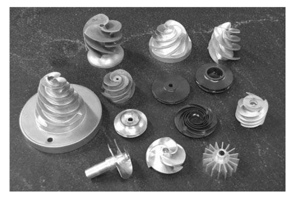 Various spiral-shaped metal components are arranged on a dark surface.