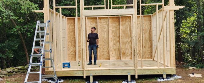 Image of Maksym in his backyard building a shed for his family